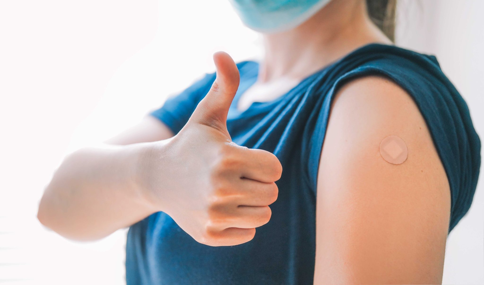 Woman Giving Thumbs Up and Showing Off Arm With Band-aid