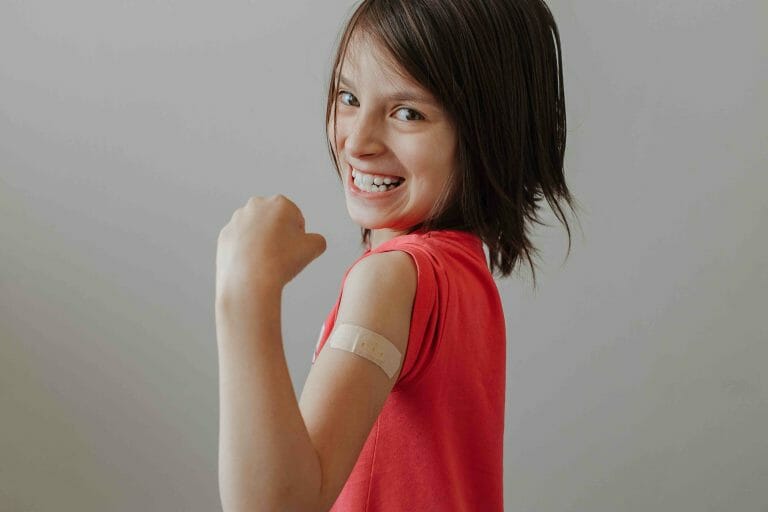 Child Smiling with Bandage on Arm