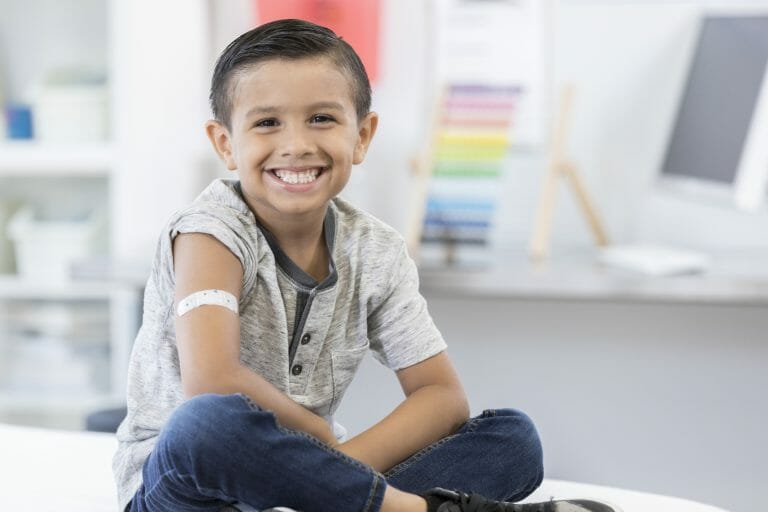 Smiling kid with a bandaid