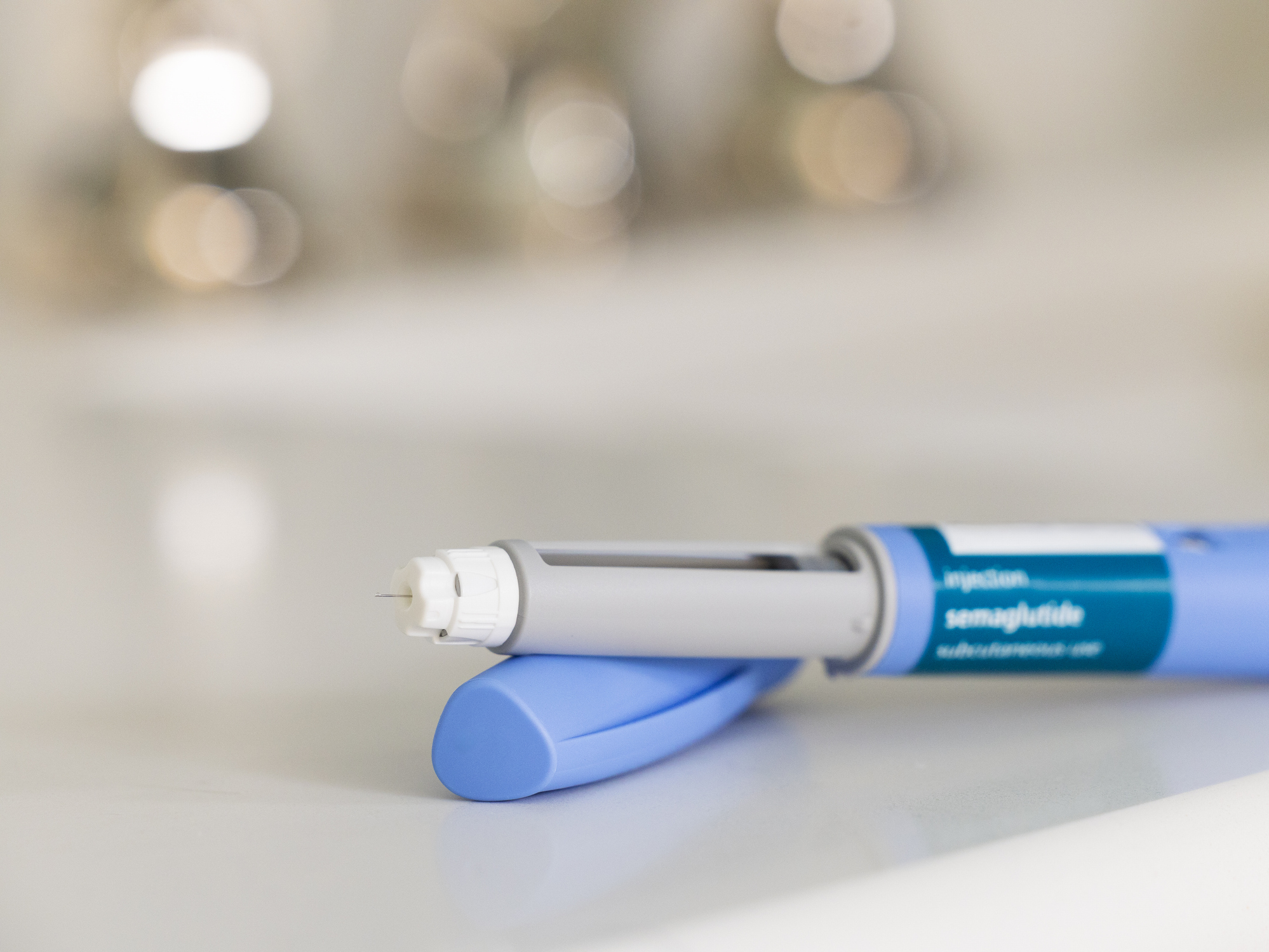 Purple injection pen with semaglutide label and needle, resting on its blue cap.